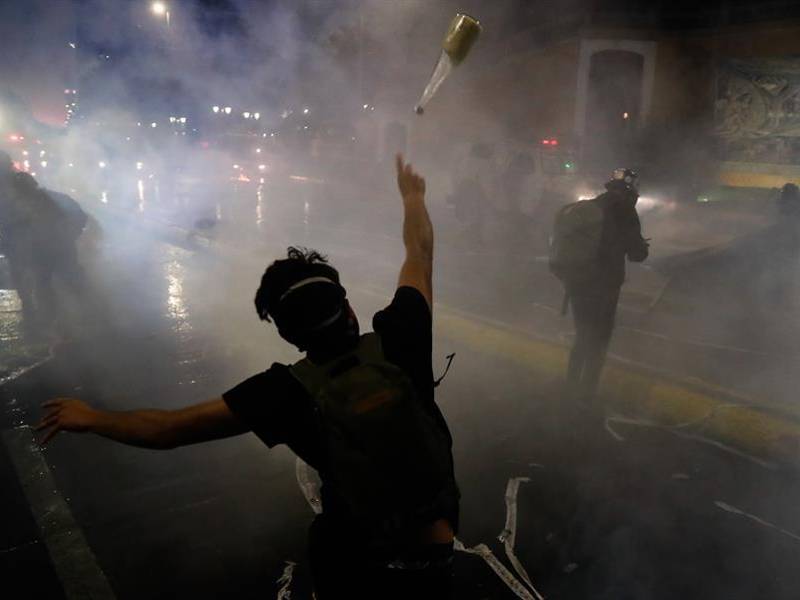 Manifestantes se enfrentan con la policía ayer en el centro de Santiago.