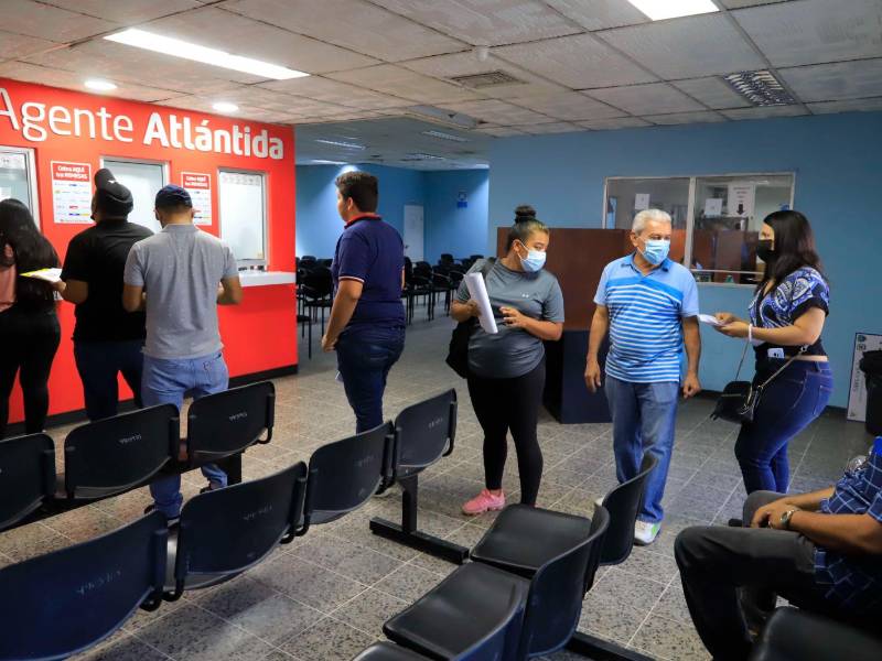 Hondureños hacen fila para pagar la constancia.