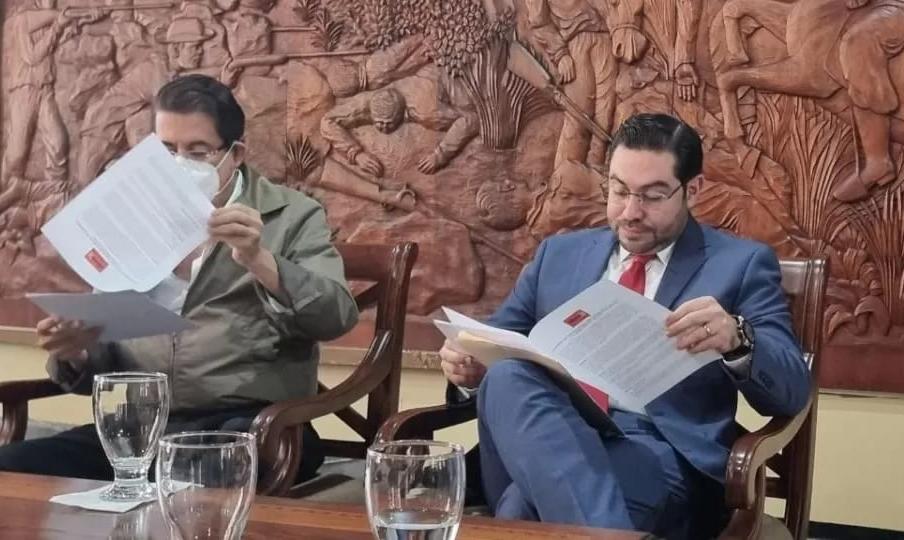 Manuel Zelaya y Jorge Cálix leen el documento previo a firmarlo.