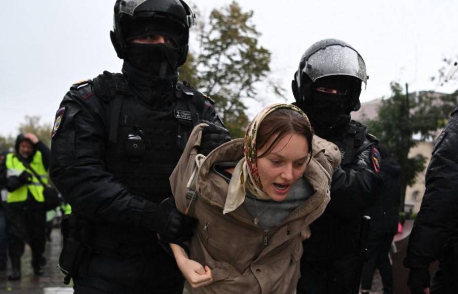 Dos agentes de la policía rusa detienen a una mujer protestante. Según OVD-Info, una organización especializada en el recuento de arrestos, al menos “707 personas ya fueron detenidas en 32 ciudades” de toda Rusia; más de la mitad, en Moscú.
