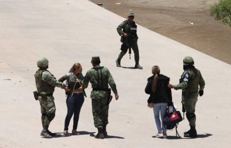 Members of Mexican National Guard detain Central American migrants trying to cross the Rio Bravo, in Ciudad Juarez, State of Chihuahua, on June 21, 2019. - Mexican President Andres Manuel Lopez Obrador suggested Friday he and US counterpart Donald Trump should hold their first meeting in September to review progress on the countries' recent migration deal. (Photo by HERIKA MARTINEZ / AFP)