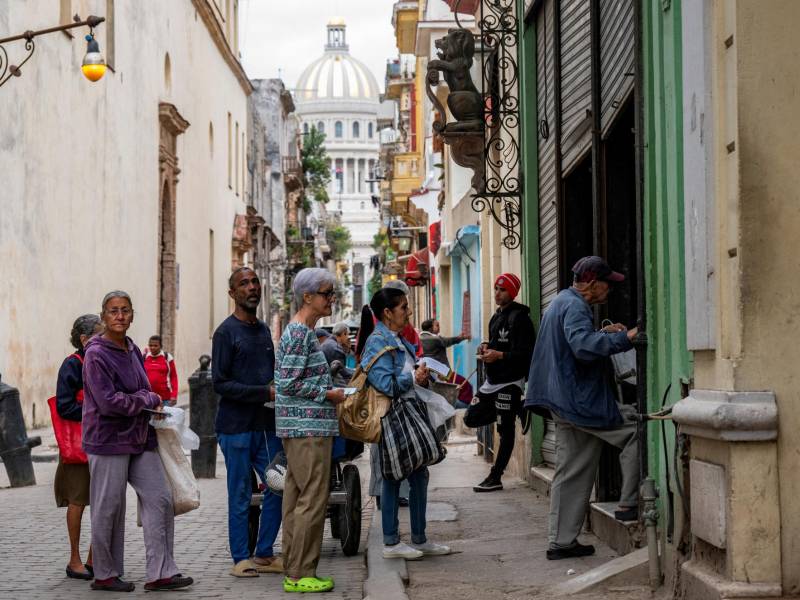 Un grupo de personas hace fila en una panadería en La Habana.
