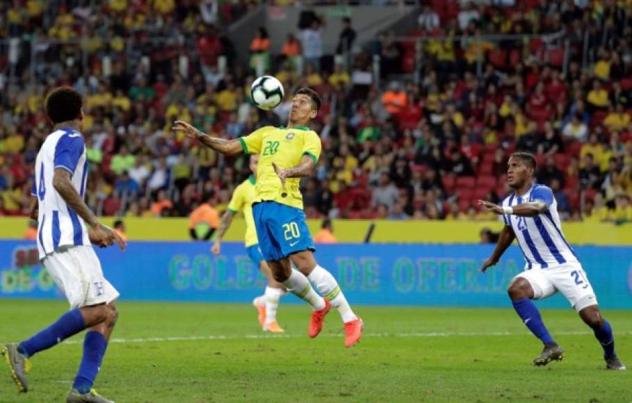 Roberto Firmino, que hizo el 6-0, baja el balón de gran manera ante las miradas de Brayan Beckeles y Henry Figueroa.