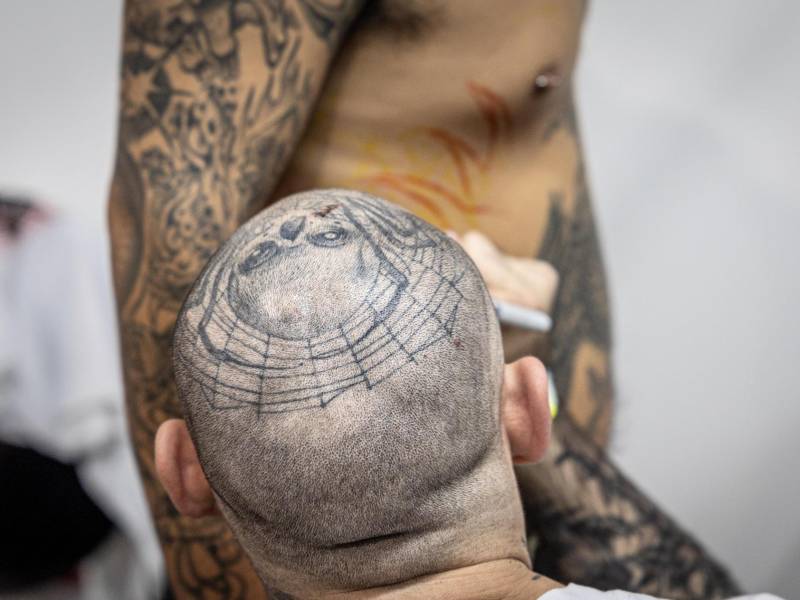 Un tatuador trabaja en el costado de una persona, durante una convención de tatuadores este sábado en Ciudad de Guatemala.