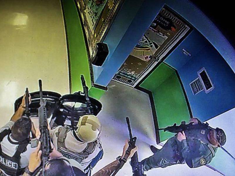 Imágenes de cámaras de seguridad muestran a los oficiales armados y con escudos balísticos esperando en las afueras del salón de clase donde ocurrió la masacre.