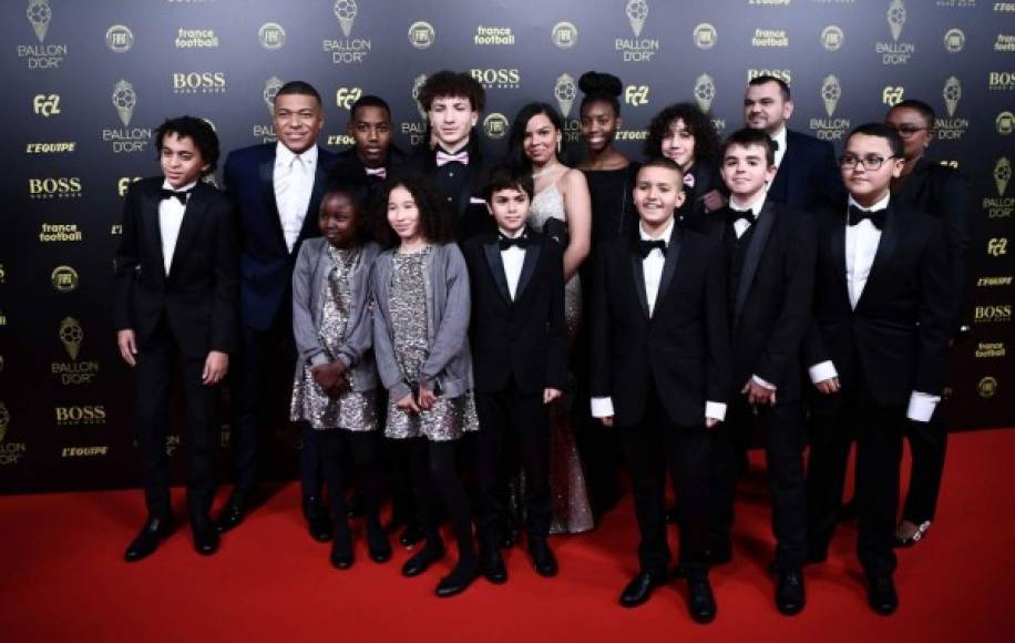 Kylian Mbappé, posando con varios niños en la Alfombra Roja.