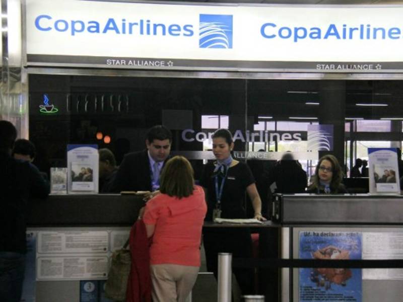 Tres empleados de Copa Airlines atienden a dos pasajeros en el aeropuerto Ramón Villeda Morales. Foto: Cristina Santos