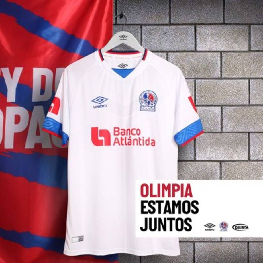 La principal camiseta lleva el traidicional color blanco, con un cuello tipo 'V' y las mangas en color azul y rojo.