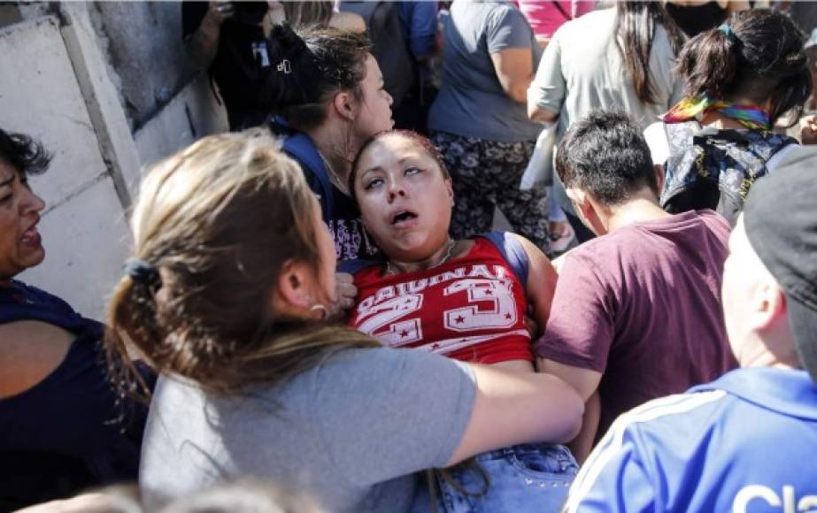 Una pariente de un recluso de la cárcel 'Santiago 1' de Chile se desmaya afuera de la prisión después de que un gran número de prisioneros intentaran escapar en medio del pánico por la propagación del coronavirus en Santiago. Foto AFP