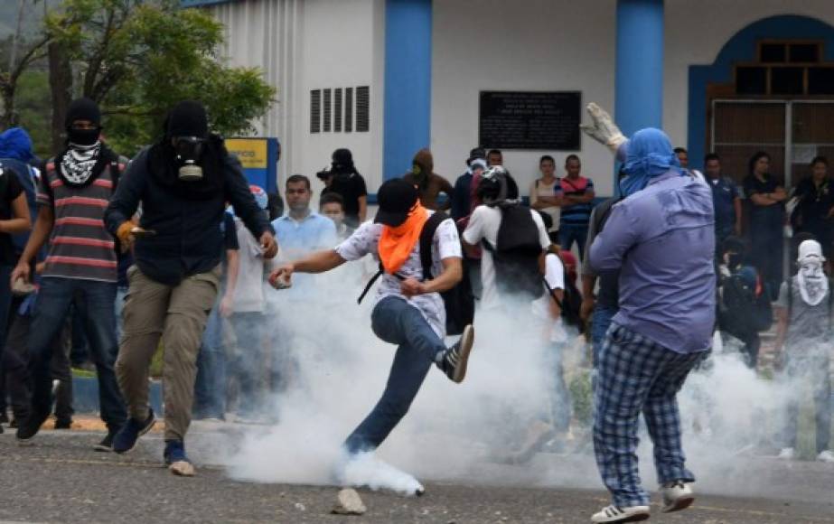 Students of the National Autonomous University of Honduras (UNAH) gathered under the University Student Movement (MEU) clash with the riot police during a demonstration to demand, among other things, the resignation of rector Julieta Castellanos, in Tegucigalpa, on July 25, 2017.<br/>The MEU, who is occupying several buildings of the UNAH since June 13 preventing some 50,000 students from attending classes, also demands the cessation of the 'criminalization' of protests, the suspension of student hearings and support to appoint delegates to the University Council, UNAH's main decision-making body. / AFP PHOTO / Orlando SIERRA