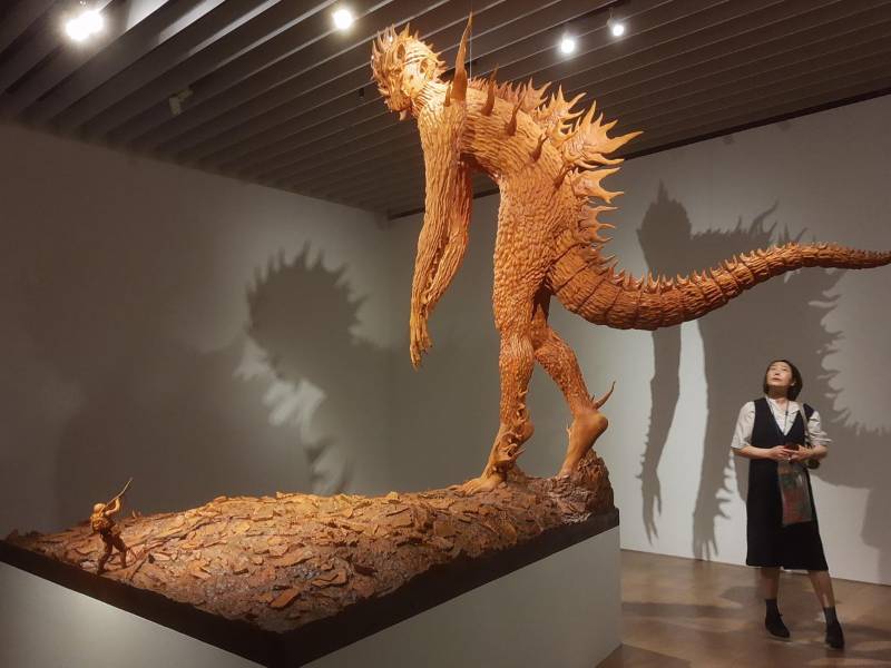 Una mujer observa la obra 'the One', del japonés Motohiko Odani, en la exposición 'Godzilla the Art' en la Mori Arts Center Gallery de Tokio, una muestra donde una treintena de artistas internacionales invitan a cuestionarse lo que vemos en el día a día a través de sus representaciones de la criatura, que plasman desde en 'fake news' hasta juguetes de cartón, gigantes de madera o esculturas de cristal. EFE/ María Roldán