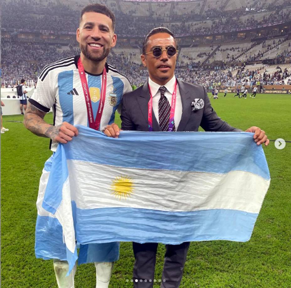 Varios jugadores argentinos sabían quién era el famoso cocinero. Acá posando con Nicolás Otamendi y la bandera de Argentina.