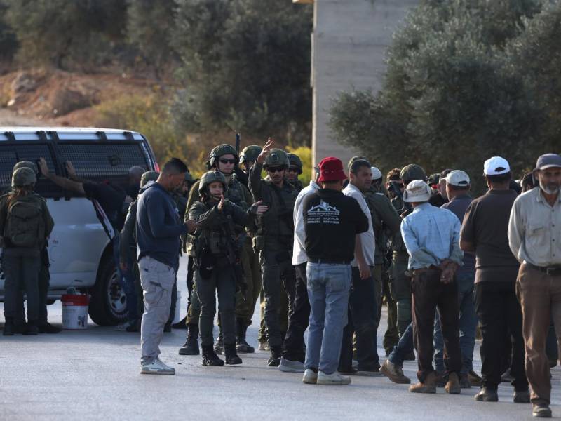 Tropas israelíes detienen a agricultores palestinos para realizar registros mientras intentan llegar a sus tierras para la cosecha de aceitunas, a pesar de haber realizado una coordinación previa, cerca de la localidad de Beita, al sur de Nablus, en Cisjordania, el 20 de octubre de 2026. EFE/EPA/ALAA BADARNEH