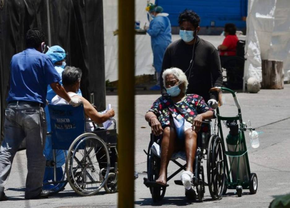 Un paciente de COVID-19 es trasladado a una de las cuatro carpas instaladas para tratar casos del nuevo coronavirus en el estacionamiento del Hospital Escuela de Tegucigalpa. AFP