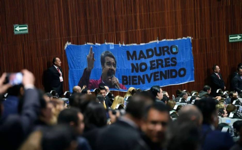 Un cartel que dice 'Maduro, no son bienvenidos' cuelga en el Congreso de la Unión, en la Ciudad de México, durante la ceremonia de inauguración del Presidente de México, Andrés Manuel López Obrador.