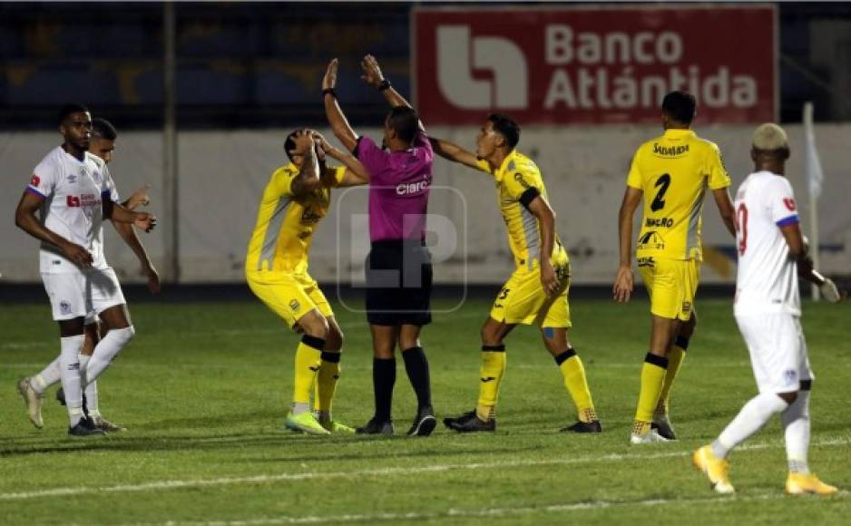 El árbitro Melvin Matamoros al momento de invalidar el gol de Devron García y los jugadores del Real España no lo podían creer.