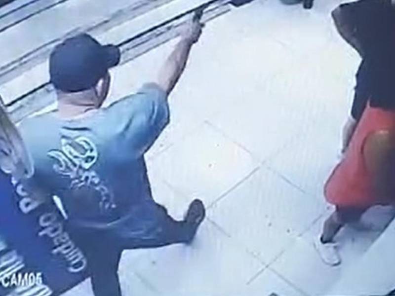 El violento suceso se registró este viernes. Captura del momento en que el hombre le dispara al guardia de seguridad.