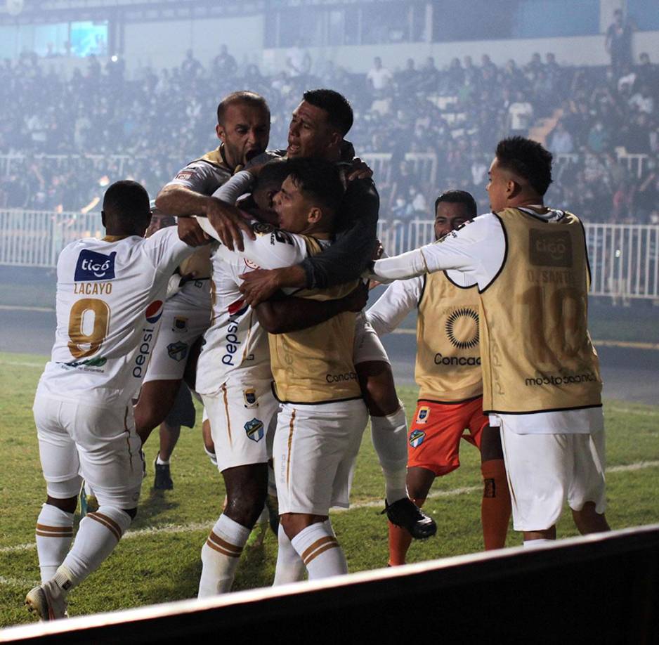 Los jugadores del Comunicaciones celebrando el gol del triunfo cerca de una esquina de la cancha.