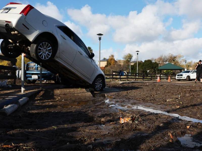 Un vehículo movido por las inundaciones que permanece atrapado en una cerca el día después de que una tormenta que inundó áreas del condado de San Diego. AFP