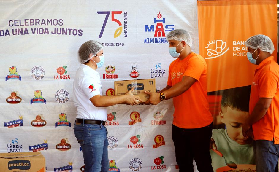 Kaleb Delcid entregando la donación a Bryan Menjívar y Bayron Arellano, ambos de Banco de Alimentos Honduras.