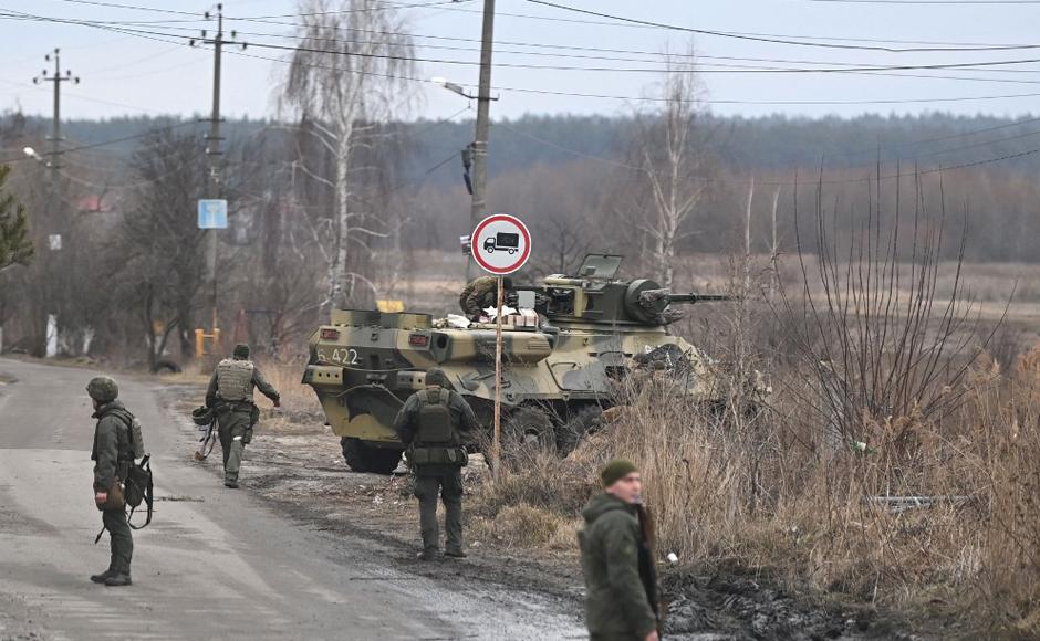 Los militares ucranianos se paran cerca de un vehículo blindado de transporte de personal BTR-3 en el noroeste de Kiev.