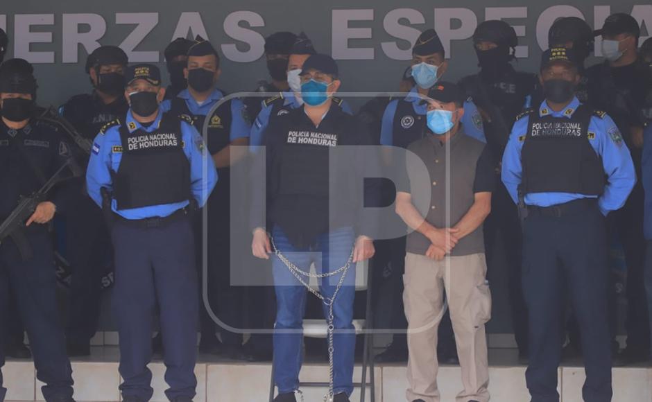 Agentes policiales rodeando al exgobernante hondureño mientras estaba totalmente esposado.