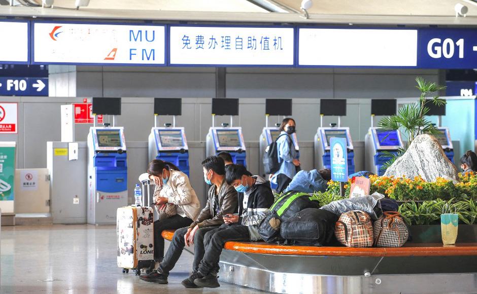 Pasajeros se sientan frente a las máquinas de autoservicio de China Eastern Airlines, en el Aeropuerto Internacional Kunming Changshui, luego de que un avión se estrellara en el suroeste.