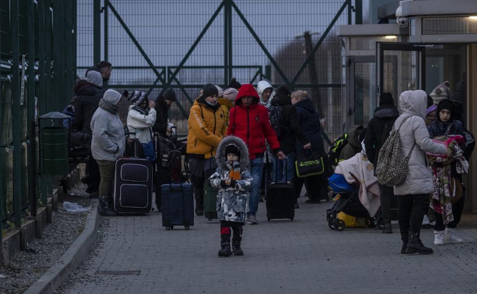 Se ve a ciudadanos ucranianos llegando al cruce fronterizo peatonal de Medyka en el este de Polonia, huyendo del conflicto en su país, un día después de que Rusia lanzara un ataque militar.