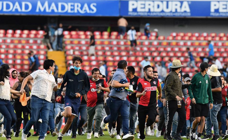 Los seguidores del equipo de fútbol Atlas ingresan al campo durante el partido del torneo de fútbol mexicano.