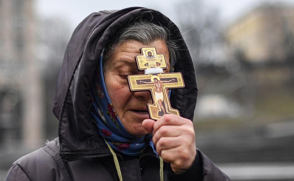Una mujer religiosa sostiene una cruz mientras reza en la plaza de la Independencia en Kiev.