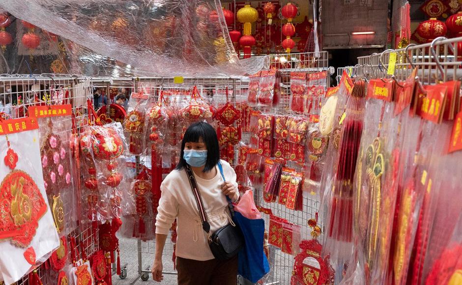 Una mujer mira los adornos festivos a la venta en un puesto en el área de Sham Shui Po de Hong Kong.