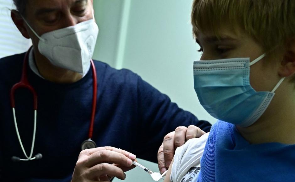El médico pediatra Jakob Maske vacuna a un niño de 11 años en su oficina en Berlín.