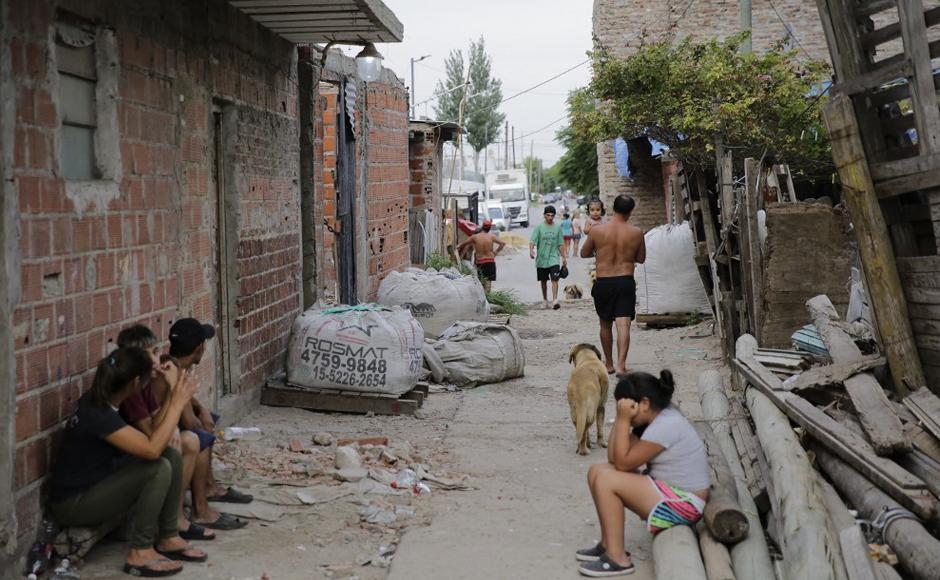 Se ve a los lugareños en un corredor del barrio pobre Puerta 8, provincia de Buenos Aires, después de que la Policía allanó una casa en busca de cocaína adulterada.