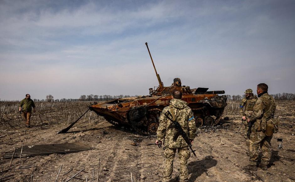 Soldados ucranianos junto a un tanque ruso quemado en las afueras de Kiev.