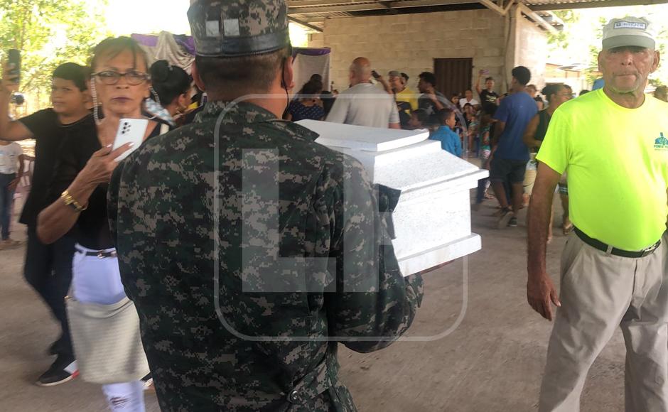 Un militar cargando el ataúd que contiene el cuerpo de la bebé, quien también fue atacada con machete.