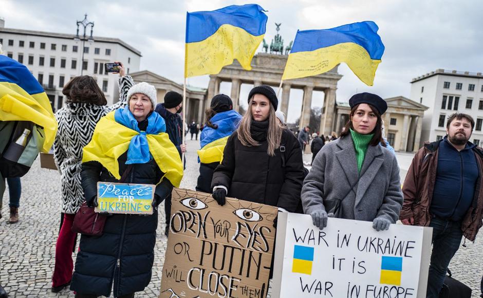 Los manifestantes exhiben pancartas que critican al presidente ruso Vladimir Putin cerca de la frontera con Ucrania.