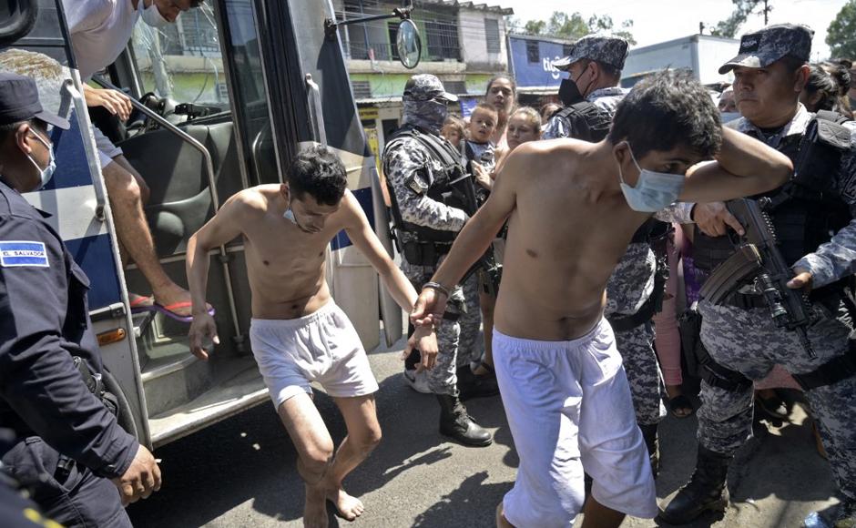 Hombres capturados por supuestos vínculos con pandillas son escoltados por la Policía Nacional Civil.