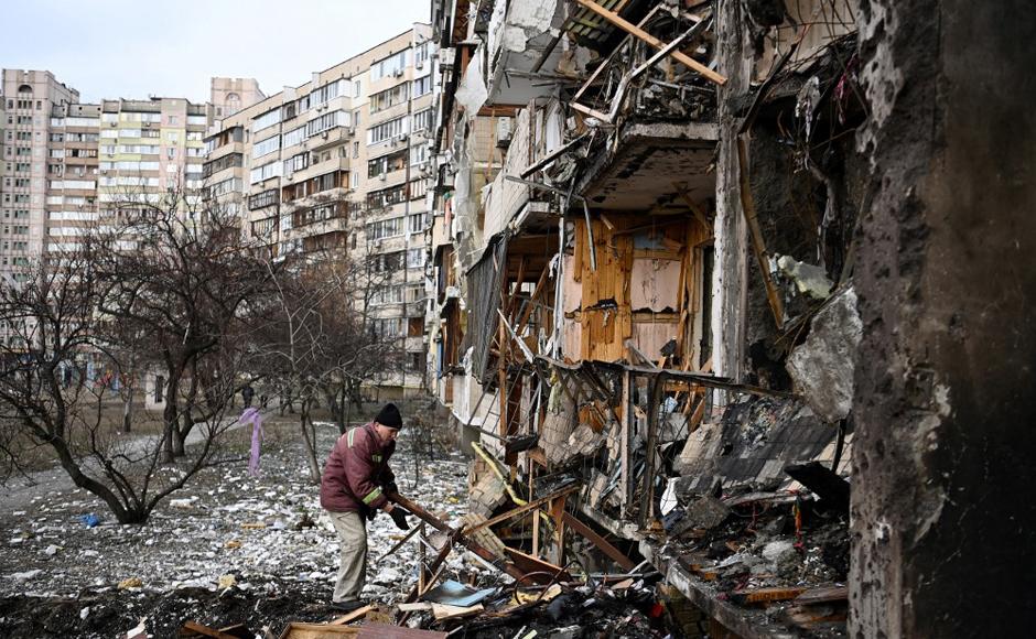 Un hombre limpia los escombros en un edificio residencial dañado en la calle Koshytsa, un suburbio de la capital ucraniana Kiev.
