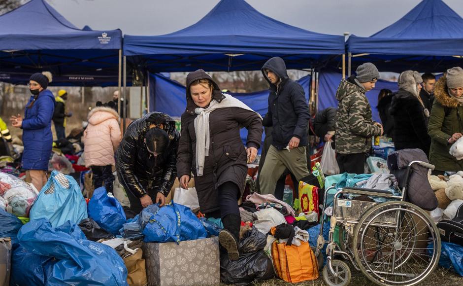 Voluntarios brindan ayuda a los refugiados ucranianos cuando llegan en autobuses desde el cruce fronterizo peatonal de Medyka, en Przemsyl, este de Polonia.