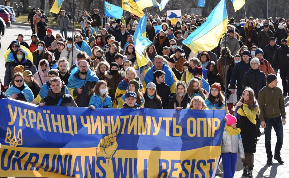 La gente marcha detrás de una pancarta que dice “Los ucranianos resistirán” durante una manifestación en el centro de la ciudad de Lviv, en el oeste de Ucrania, para mostrar su unidad mientras aumentan los temores de que Rusia pueda invadir en los próximos días.
