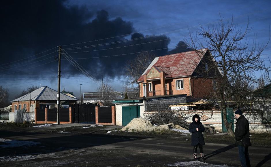 Humo negro se eleva desde un aeropuerto militar en Chuguyev cerca de Kharkiv, Ucrania.