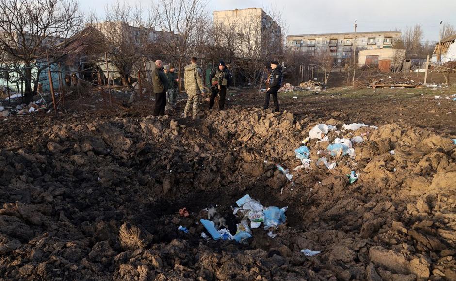 Los militares ucranianos inspeccionan un cráter cerca de una casa que fue destruida por las fuerzas rusas en el pueblo de Bachtanka cerca de Mykolaiv.