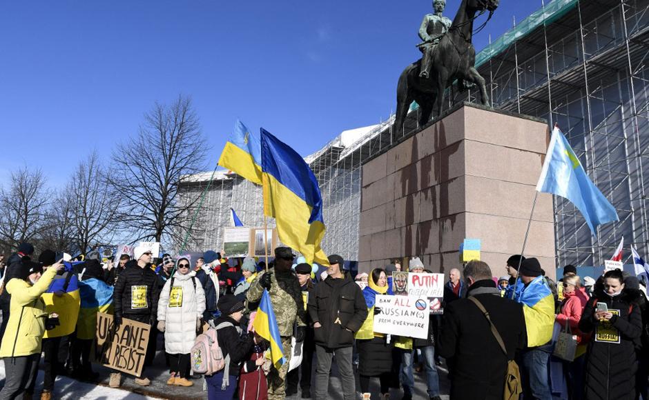 Los manifestantes ondean banderas ucranianas para mostrar su apoyo a Ucrania durante una manifestación “Estamos con Ucrania”, en Helsinki, Finlandia.