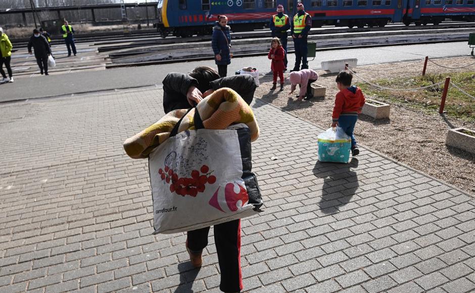 Los niños refugiados llevan sus equipajes en la estación de tren de Zahony, en la frontera entre Hungría y Ucrania.