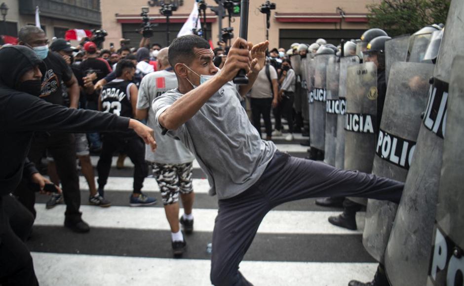 La gente choca con la policía antidisturbios durante una protesta contra el Gobierno del presidente de Perú.