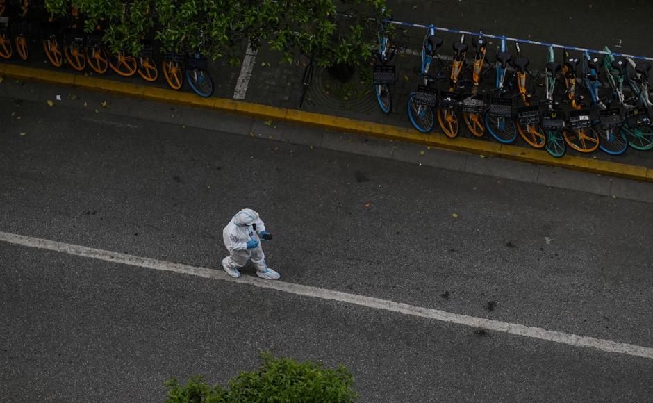 Un policía con equipo de protección personal camina por una calle durante el bloqueo del coronavirus.