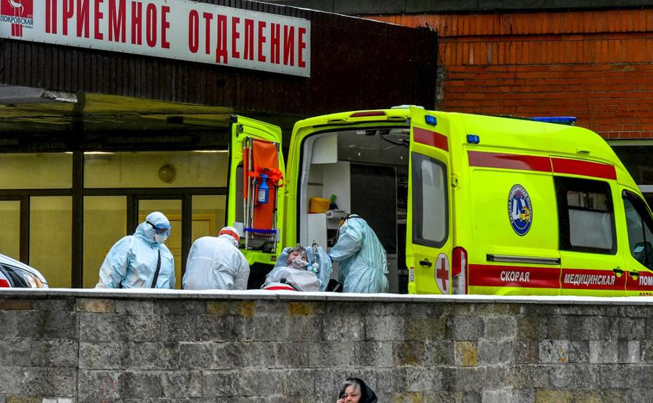 Personal médico saca de una ambulancia a una persona en la sección de pacientes infectados con covid-19 en el hospital Pokrovskaya en San Petersburgo.