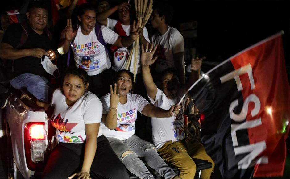 Simpatizantes del presidente de Nicaragua, Daniel Ortega, posan con una bandera del Frente Sandinista de Liberación Nacional (FSLN).