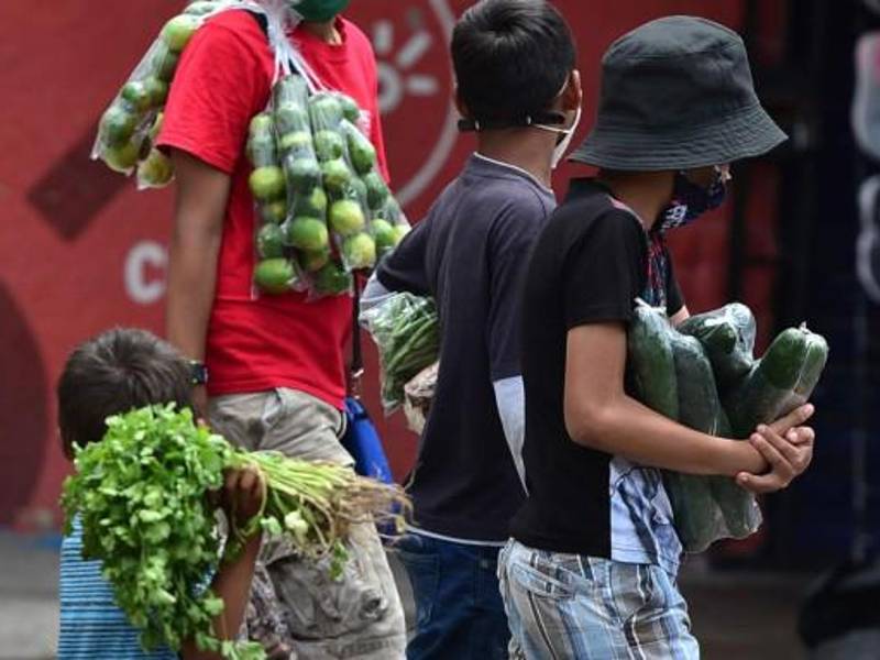Los niños venden frutas y verduras en la calle en Tegucigalpa en medio de la pandemia del coronavirus.