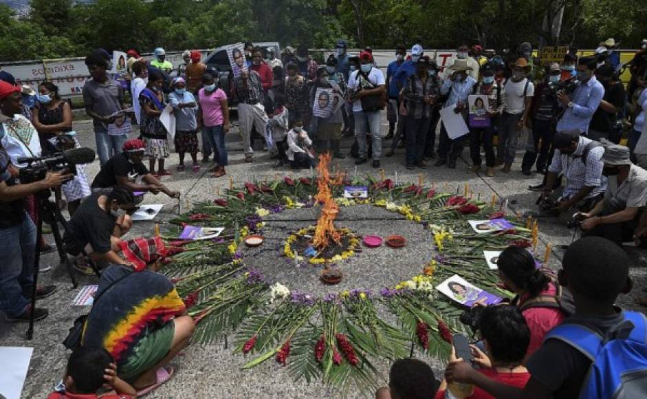Integrantes del Copinh rodeando un incendio mientras esperaban la lectura de la sentencia. Foto AFP